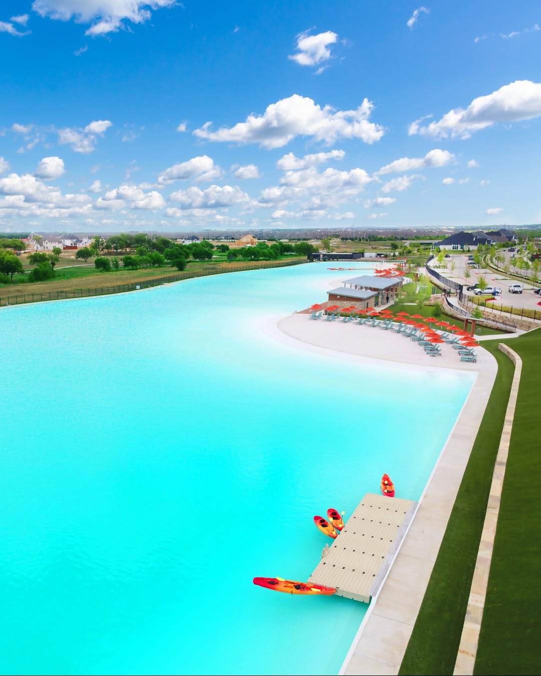 Aerial view of the Windsong Ranch Crystal Lagoon with turquoise water and sandy beach